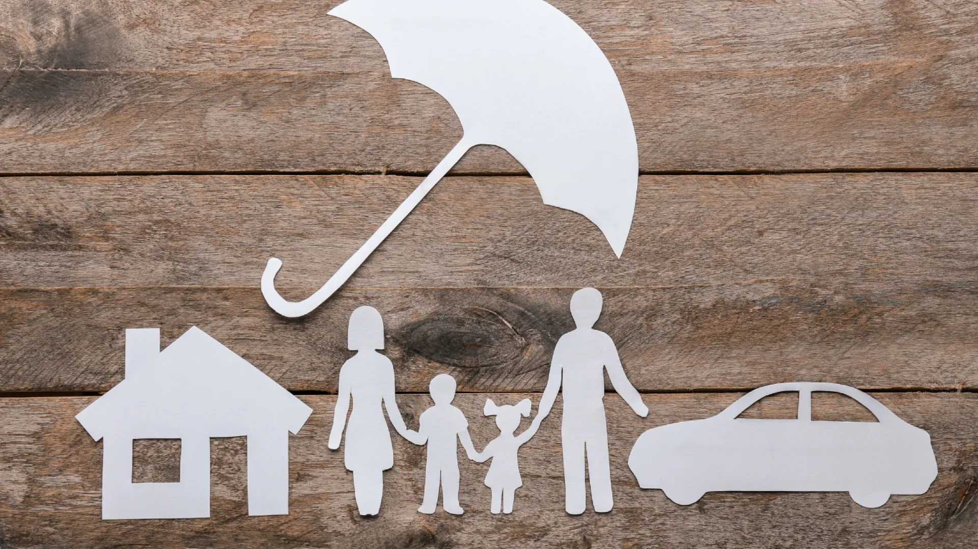 Schutzschirm über Familie, Haus und Auto als Symbol für Versicherung
